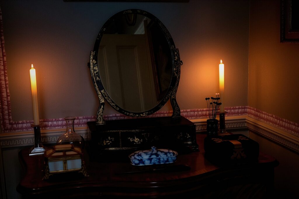 An intimate vignette within the 'Architecture of Silence,' where an antique Chinoiserie mirror captures the flickering warmth of twin candles