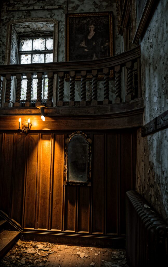 The Light on the Landing. A warm wall light glows against dark wood panelling in an abandoned stairwell